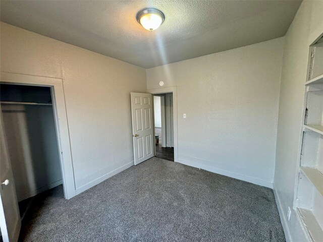 unfurnished bedroom featuring a textured ceiling, carpet floors, and baseboards