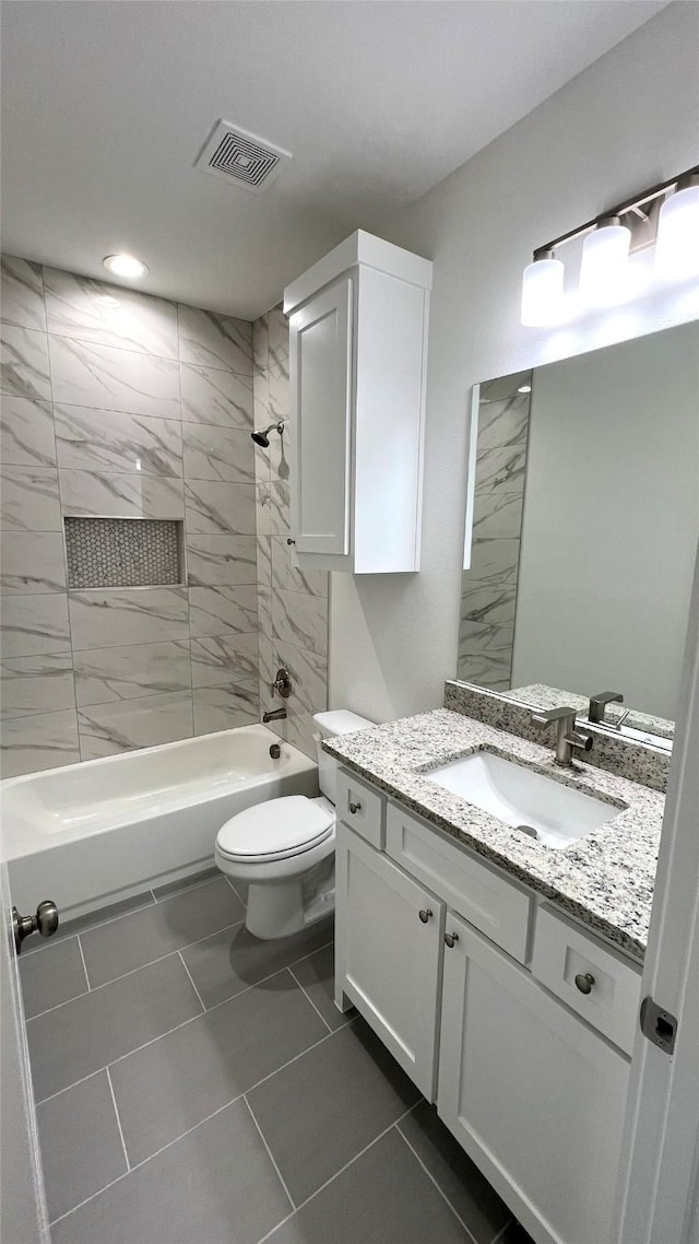 bathroom with washtub / shower combination, toilet, vanity, and visible vents