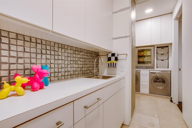 washroom featuring light tile patterned floors, laundry area, separate washer and dryer, a sink, and recessed lighting