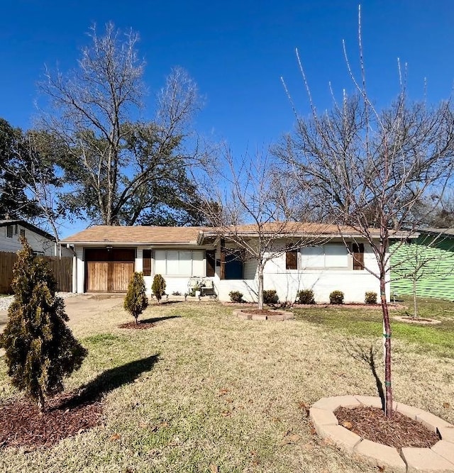 ranch-style house featuring a garage, a front yard, and fence