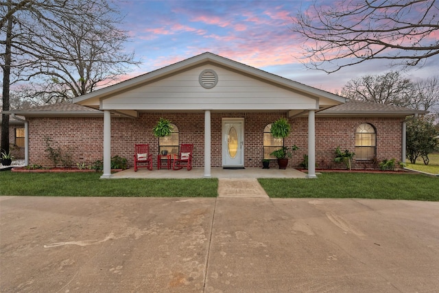 view of front facade featuring a lawn and brick siding