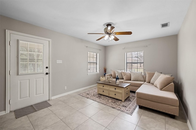 living room featuring a ceiling fan, a healthy amount of sunlight, visible vents, and baseboards