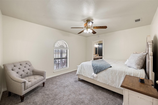 carpeted bedroom featuring a ceiling fan, visible vents, baseboards, and ensuite bathroom