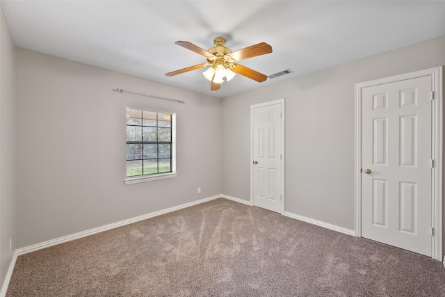 unfurnished room with baseboards, ceiling fan, visible vents, and carpet flooring