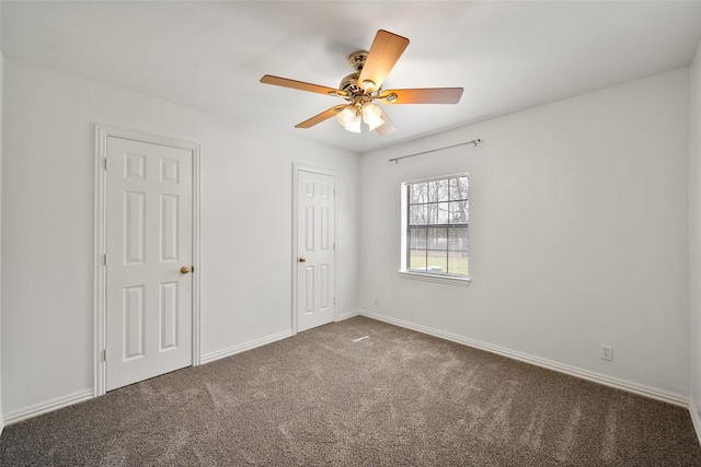 unfurnished room featuring a ceiling fan, carpet flooring, and baseboards