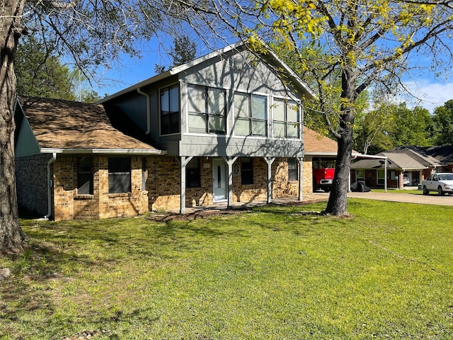 view of front of property with brick siding, concrete driveway, and a front yard