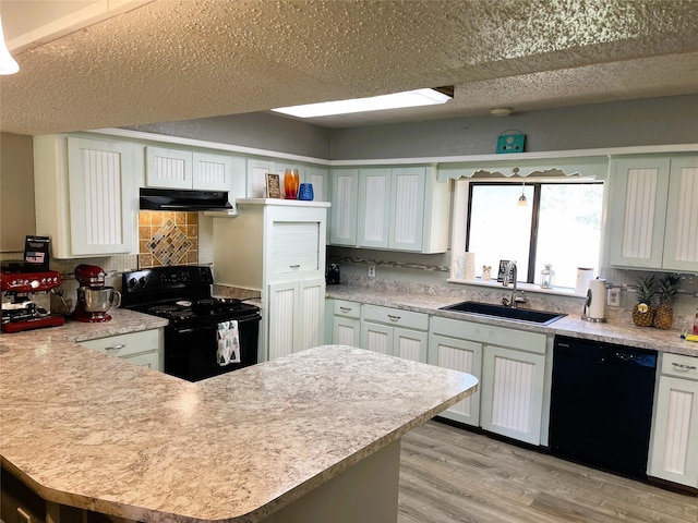 kitchen with black appliances, a sink, light countertops, and under cabinet range hood