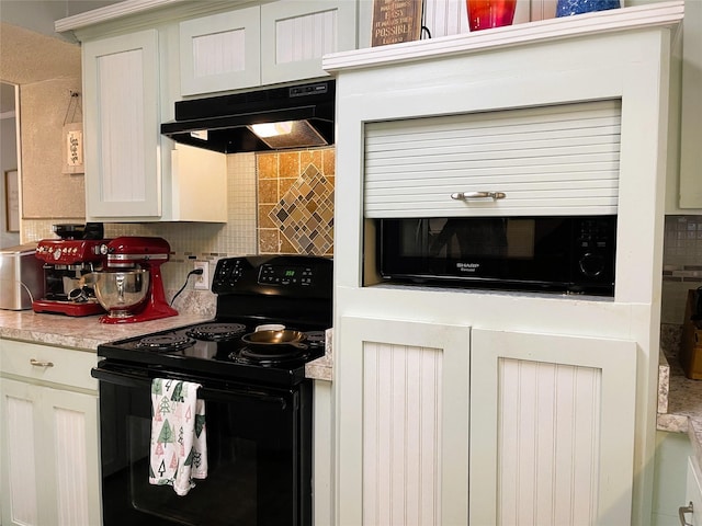 kitchen with under cabinet range hood, black / electric stove, decorative backsplash, and light countertops