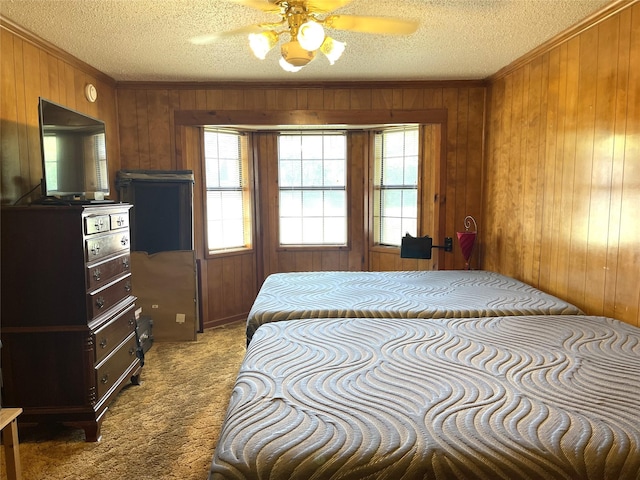 bedroom with ornamental molding, carpet, wood walls, and a textured ceiling