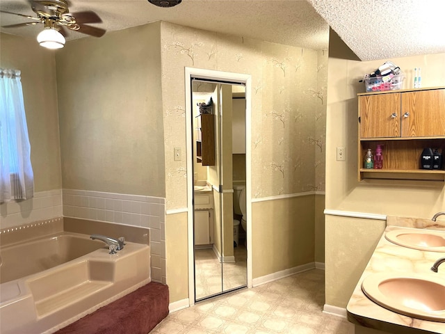 full bathroom with a bath, a textured ceiling, a sink, and tile patterned floors