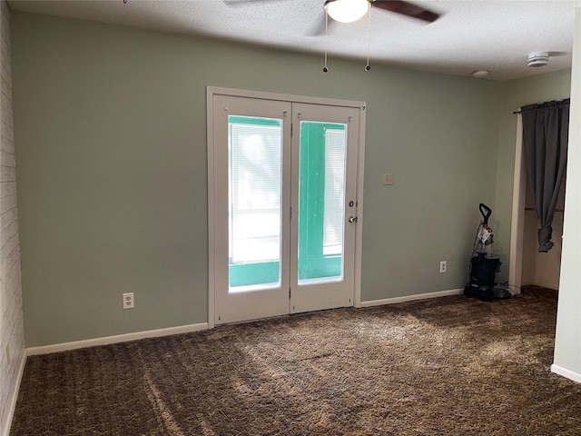 spare room featuring a textured ceiling, ceiling fan, carpet flooring, and baseboards