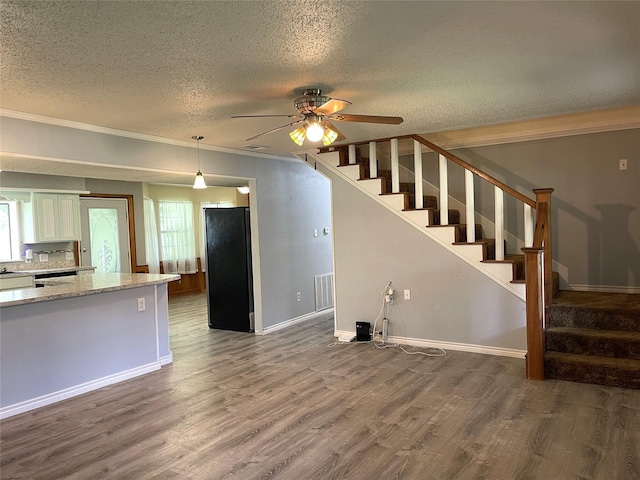 806 Robindale Ln, Fairfield, TX 75840 - unfurnished living room featuring a textured ceiling, wood finished floors, stairway, ceiling fan, and plenty of natural light