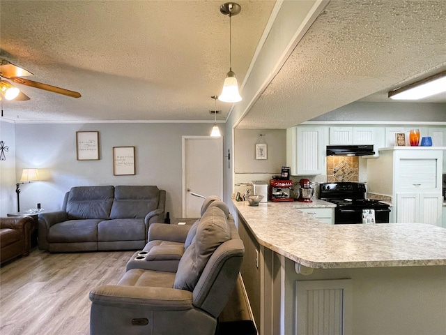 kitchen with light wood-style floors, light countertops, a peninsula, and black / electric stove