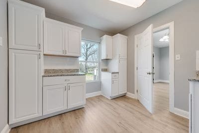 kitchen featuring light wood-style floors, white cabinetry, and baseboards