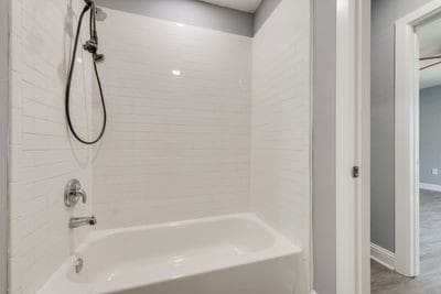 bathroom with washtub / shower combination and baseboards