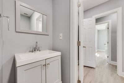 bathroom with baseboards, wood finished floors, and vanity