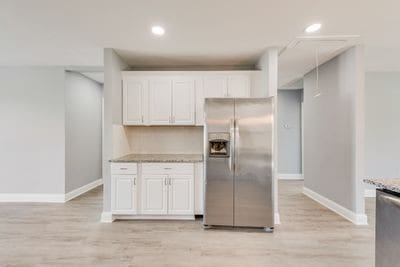 kitchen featuring baseboards, appliances with stainless steel finishes, light wood-style flooring, and white cabinets