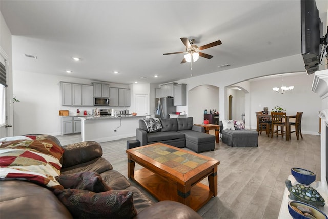 3512 Tunnel Ave, Aubrey, TX 76227 - living room featuring arched walkways, ceiling fan, light wood-type flooring, a chandelier, and recessed lighting