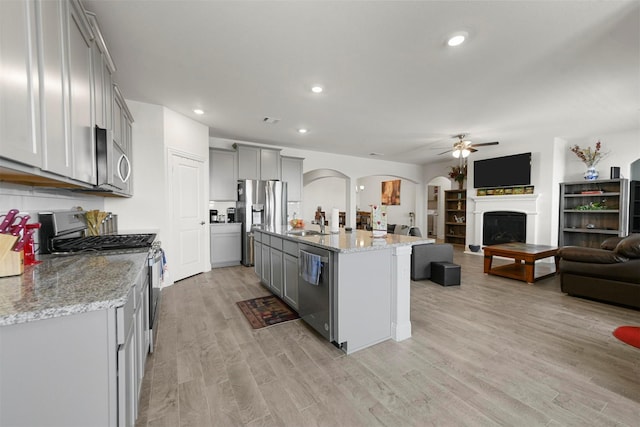 3512 Tunnel Ave, Aubrey, TX 76227 - kitchen with gray cabinets, open floor plan, stainless steel appliances, arched walkways, and a ceiling fan