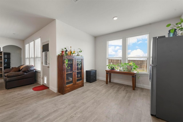 3512 Tunnel Ave, Aubrey, TX 76227 - kitchen featuring freestanding refrigerator, light wood-style floors, baseboards, and arched walkways