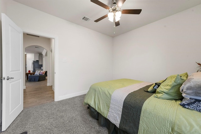 3512 Tunnel Ave, Aubrey, TX 76227 - bedroom featuring arched walkways, carpet floors, freestanding refrigerator, baseboards, and a ceiling fan