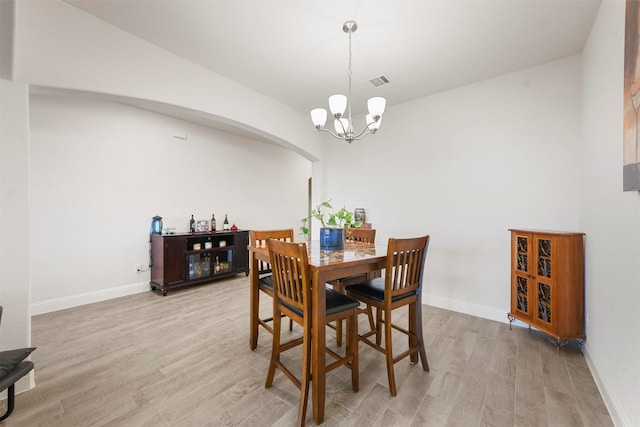 3512 Tunnel Ave, Aubrey, TX 76227 - dining room with light wood-type flooring, a chandelier, arched walkways, and baseboards