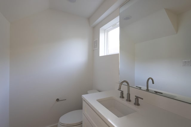 bathroom with lofted ceiling, visible vents, vanity, and toilet