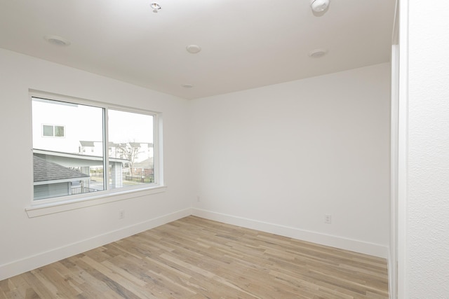 empty room with light wood finished floors and baseboards