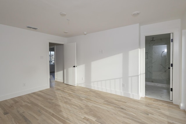 empty room featuring baseboards, visible vents, and wood finished floors