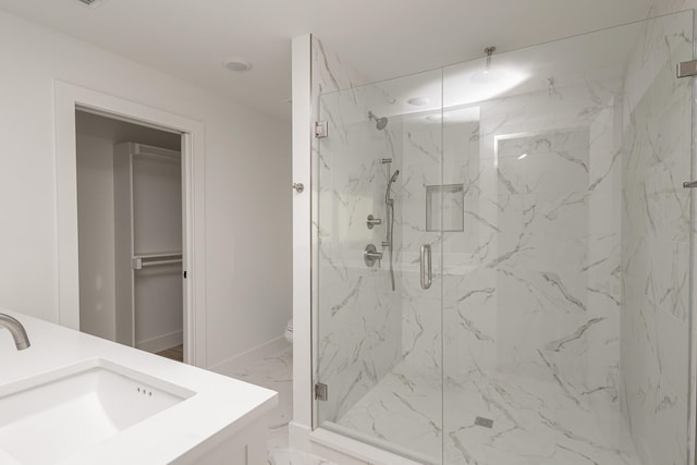 bathroom with toilet, vanity, baseboards, marble finish floor, and a marble finish shower