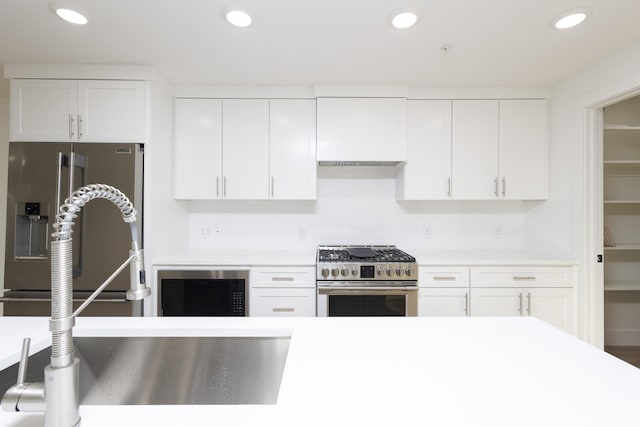 kitchen with stainless steel appliances, light countertops, white cabinetry, and recessed lighting