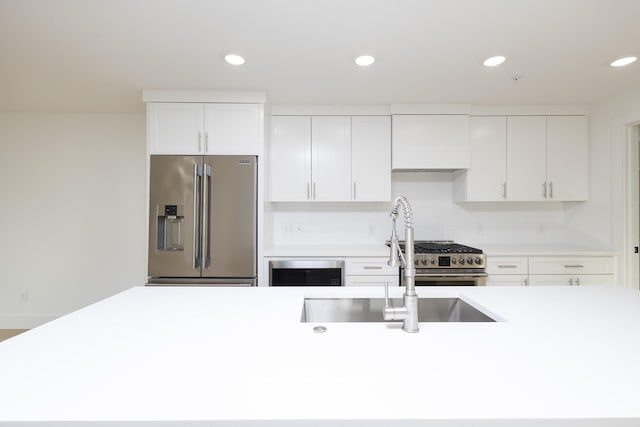 kitchen with stainless steel appliances, light countertops, and white cabinetry