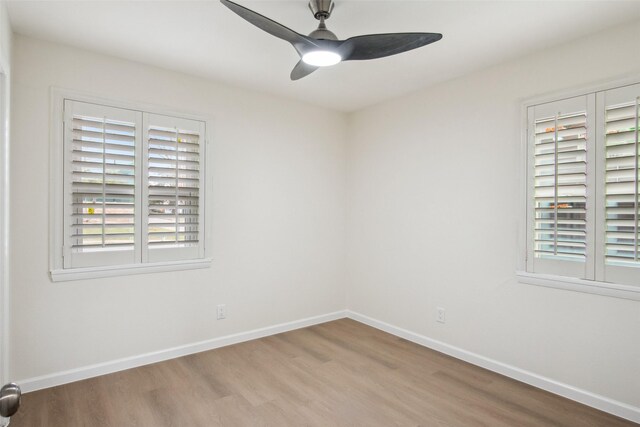 empty room with ceiling fan, baseboards, and wood finished floors