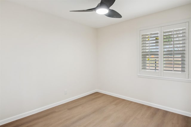 empty room featuring a ceiling fan, baseboards, and wood finished floors