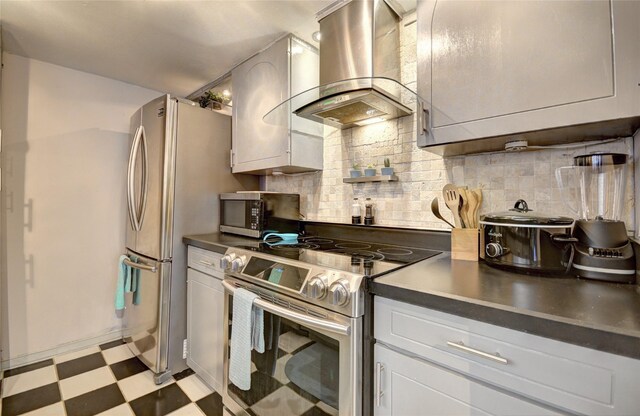 kitchen featuring appliances with stainless steel finishes, range hood, decorative backsplash, and light floors