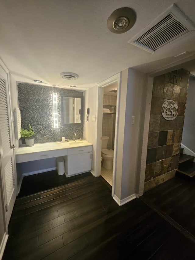 bathroom featuring visible vents, vanity, toilet, and wood finished floors