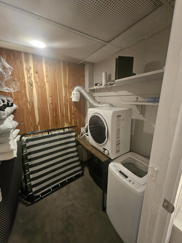 laundry room with wood walls, laundry area, and washer / dryer