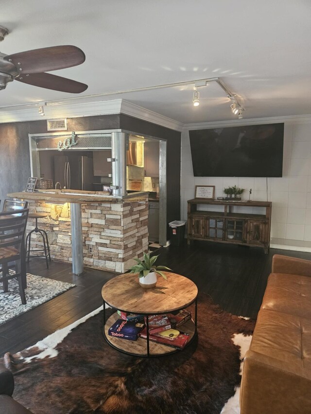 living area with visible vents, a ceiling fan, hardwood / wood-style flooring, and crown molding