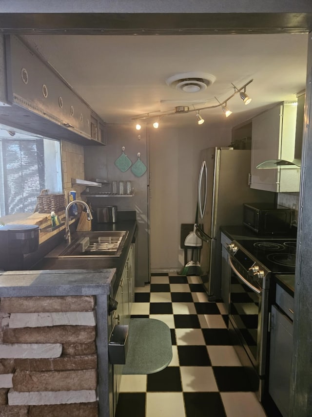 kitchen featuring dark countertops, stainless steel range with electric stovetop, light floors, black microwave, and a sink