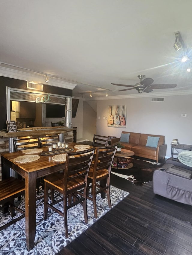 dining room featuring a ceiling fan, wood finished floors, visible vents, and crown molding