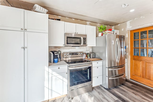 kitchen featuring light wood finished floors, light countertops, appliances with stainless steel finishes, and white cabinets