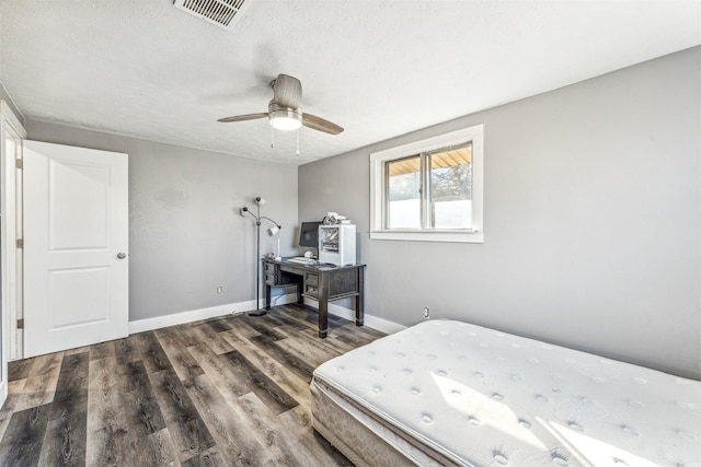 bedroom featuring a textured ceiling, wood finished floors, visible vents, and baseboards