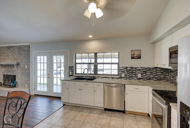 kitchen featuring stainless steel appliances, french doors, backsplash, and a sink