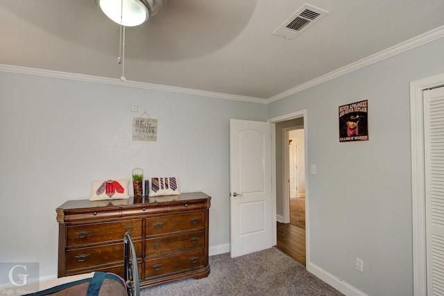 bedroom with dark colored carpet, ornamental molding, visible vents, and baseboards