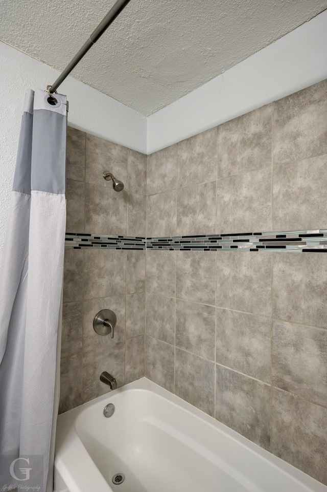 bathroom featuring a textured ceiling and shower / tub combo with curtain