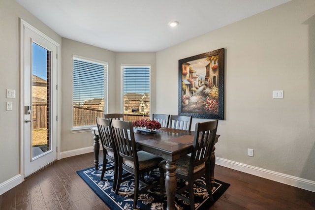 dining space with baseboards and dark wood-style flooring