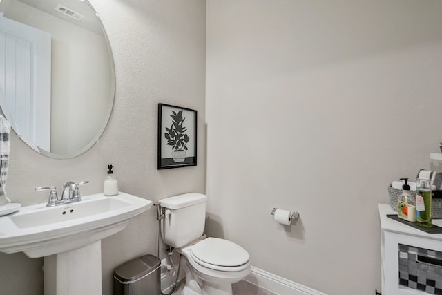 bathroom with visible vents, a sink, toilet, and baseboards