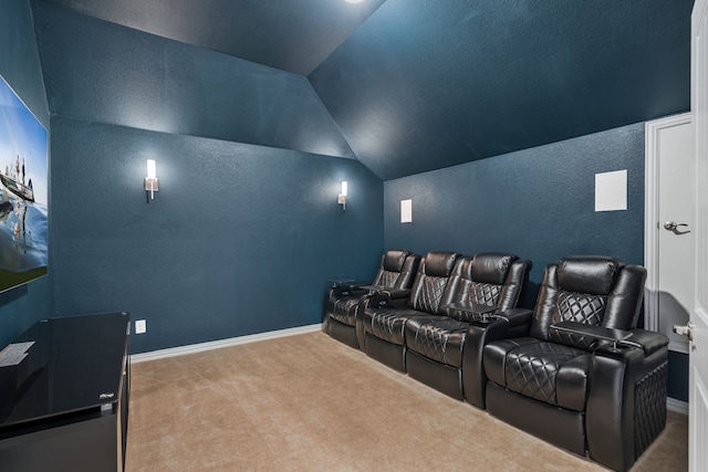 carpeted home theater with lofted ceiling, baseboards, and a textured wall