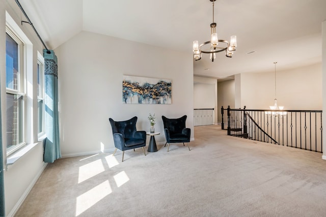 living area with vaulted ceiling, carpet floors, an upstairs landing, and a notable chandelier