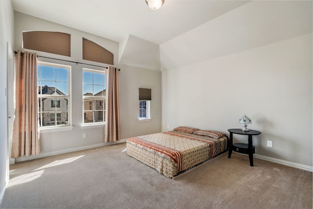 bedroom with lofted ceiling, baseboards, and carpet flooring